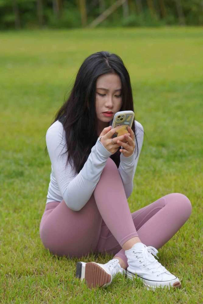 图片[1]-坐在草地玩手机的瑜伽姑娘【733P】04012-花间社